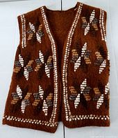 Full view of brown knit vest front showing pattern and border