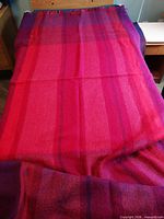 Full view of blanket spread out on a bed showing size and color pattern