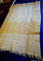 Full view of mohair blanket laid flat showing color and fringe