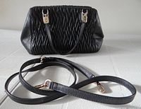 Front view of black ruched Coach handbag with strap detached
