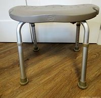 Front view of shower stool showing contoured seat and adjustable legs