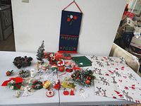 Full lot overview on table showing lights, tree, towels, felt holder, wreaths and ornaments