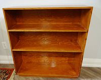Front view of wooden bookcase with three shelves