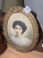 Front view of oval gold frame with portrait