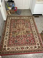 Full view of the entire red and beige oriental rug on floor