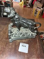 Full view of bronze roaring big cat sculpture on wooden surface