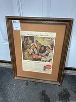 Full view of framed 1945 Coca-Cola ad in brown wood frame with tan mat