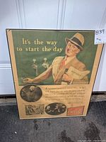 Full view of framed Coca-Cola poster standing against door