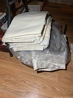 Stack of folded cream curtains and plastic-bagged contents