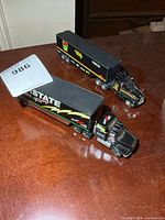 Two black NASCAR diecast transporter trucks on tabletop