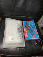 Closed plastic organizer box beside boxed wool weaving kit
