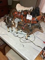 group of porcelain horses with harnesses on table