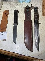 Two knives and two sheaths laid out on counter