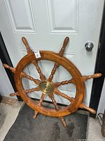 Full view of 42" solid wood ship's wheel leaning against door