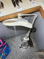 Full view of magnifier work light standing with clamp base, power cord visible