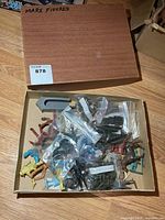 Open box showing numerous bagged and loose Marx plastic figures
