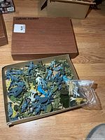 Open box showing large quantity of assorted plastic military and astronaut figures