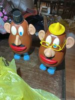 Front view of both Mr. Potato Head figures with accessories attached