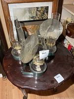 Top view of three glass oil lamps with brackets and heat deflectors on table
