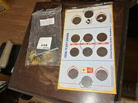 Overall lot showing display card and bag of medallions