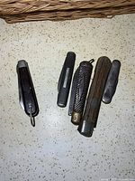 All five pocket knives closed, showing handles