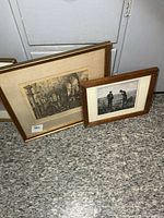 Two framed prints leaning against wall, showing relative sizes