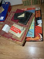 Stack showing various boxed games, domino cases and Chinese Checkers board