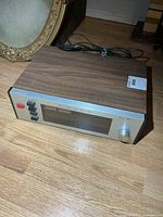 Front angled view showing full tuner with wood cabinet and controls