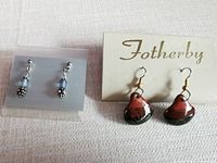 Both pairs: Fotherby teardrop earrings on card, blue bead earrings on acrylic card
