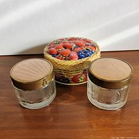 two Dominion Glass jars with metal lids and decorative fruit tin