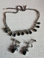 Full view of necklace and earrings on fabric background