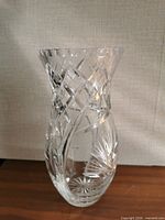 Full view of clear cut crystal vase standing on table