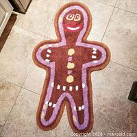 Full view of gingerbread man bath mat rug on tile floor