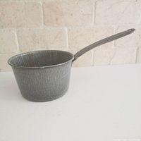 Side view of gray speckled enamel saucepan