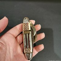 Hobo utensil closed in hand showing scale and handle detail