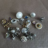 Full lot overview showing all earring pieces on cardboard