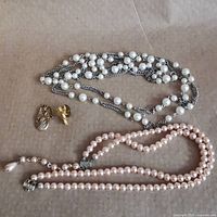 Lot overview showing both necklaces, angel pendant, cherub pin