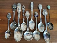Front view of ten assorted souvenir spoons