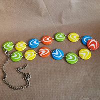 Full view of belt showing linked multicolor plastic discs and chain