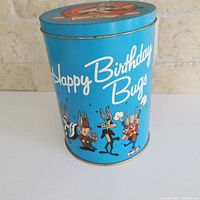 Front view of Bugs Bunny blue tin showing "Happy Birthday Bugs" text and characters