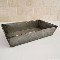 Angled view of rectangular gray spatter enamel loaf pan