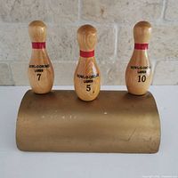 Front view of trophy showing three numbered pins and printing
