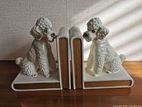 Front view of both ceramic poodle bookends showing overall design and condition