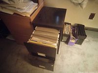 Small black 2-drawer file cabinet with top drawer open showing hanging files