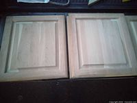 Two unfinished wood cabinet doors side by side showing front panels