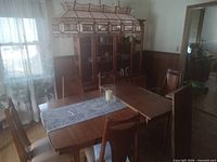 Dining table with chairs, hutch in background