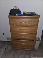 Front view showing five drawers, oak finish, top surface with personal items