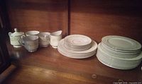 Overall view of mixed dinnerware set on shelf