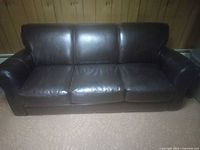 Front view of dark brown leather three-seat sofa