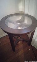 Full view of round side table showing glass top and espresso frame